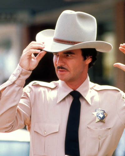Burt Reynolds tipping a cowboy hat in The Best Little Whorehouse in Texas.