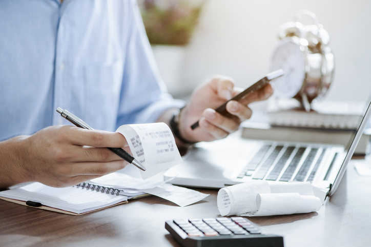 Person reviewing personal finances and tax paperwork on a laptop
